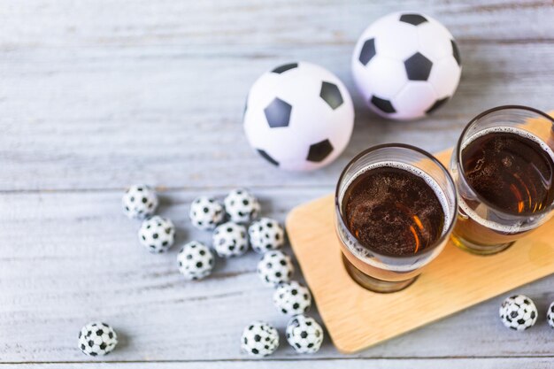 Chopes e salgadinhos em cima da mesa para festa de futebol.