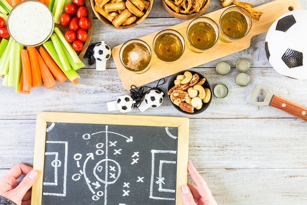 Chopes e salgadinhos em cima da mesa para festa de futebol.