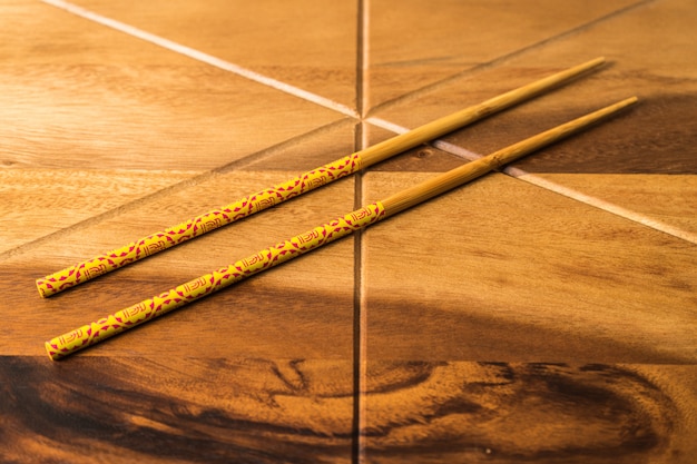 CHOPSTICKS DE BAMBÚ NATURAL sobre fondo de mesa de madera