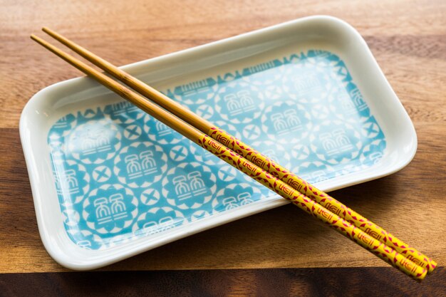 Chopsticks de bambu natural e placa no fundo da mesa de madeira