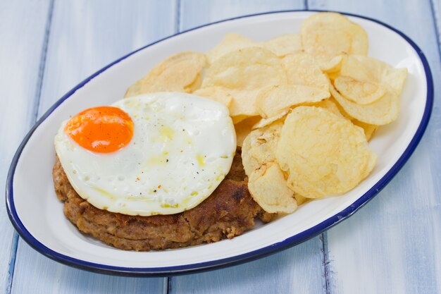 Chorizo ahumado con huevo frito y papas en un plato