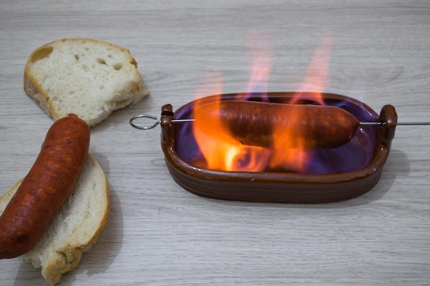 Foto chorizo al infierno prato típico da culinária espanhola chorizo em uma tigela de barro com álcool