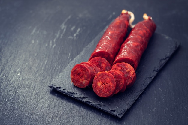 Chorizo de salchicha ahumada española sobre placa de cerámica negra