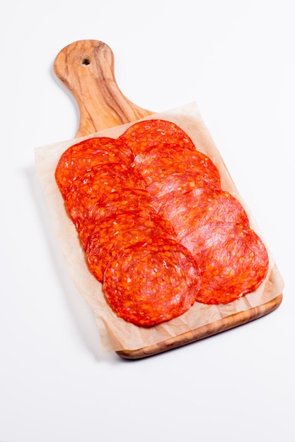 Chorizo-Wurst und Salami, dünn geschnitten. Spanische Salami auf Holzhintergrund mit Gewürzen