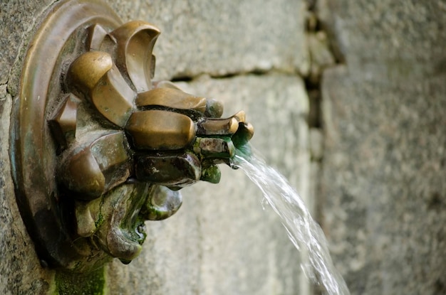 Un chorro de agua de una fuente en la pared de la calle Primer plano