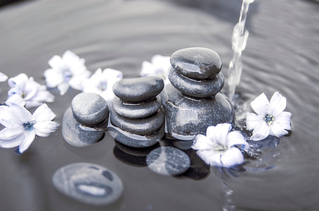 Chorro de agua sobre piedras de piedra apiladas negras