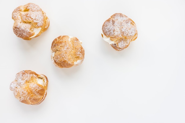 Choux Bun com chantilly e açúcar em pó na sobremesa de pastelaria francesa no fundo branco