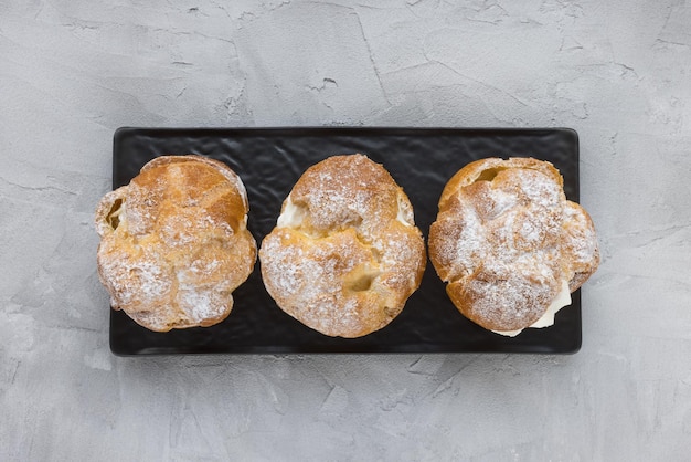 Foto choux bun con crema batida y azúcar en polvo encima postre de hojaldre choux hojaldre de crema francesa