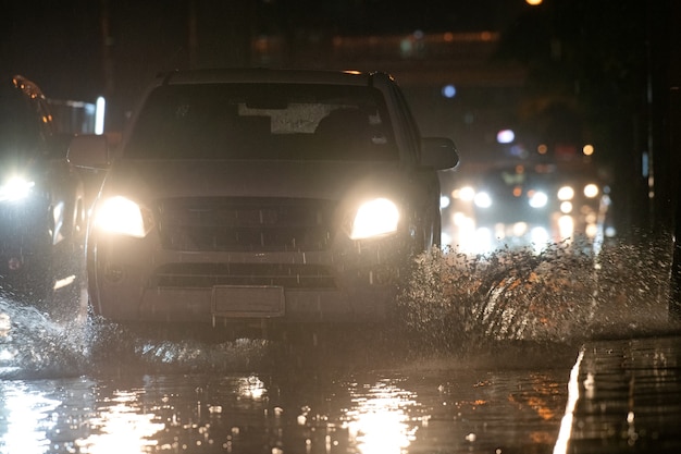 Chove na cidade nas ruas com carros e motos.