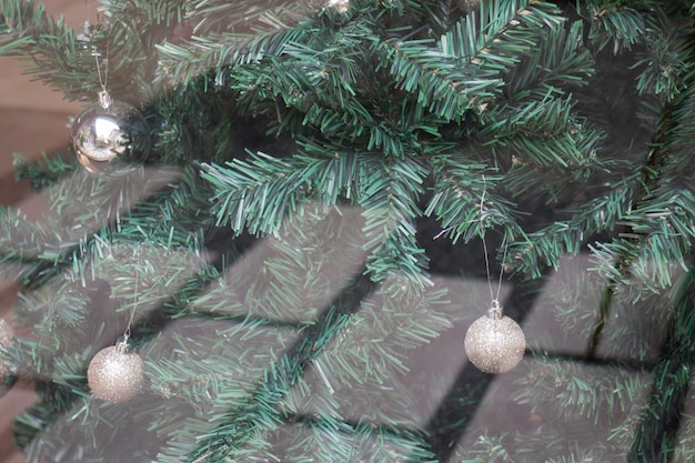 Christbaumschmuck am Fenster eines Holzhauses