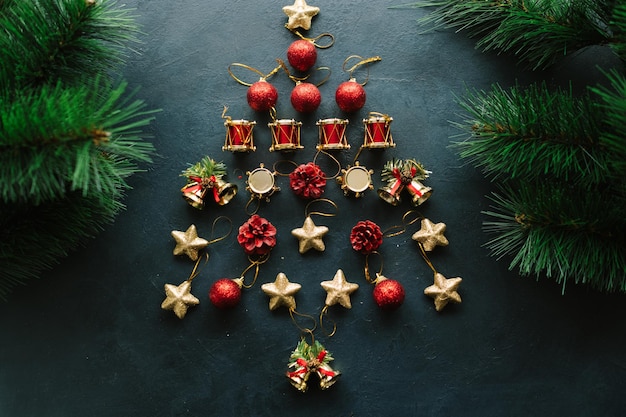 Christbaumschmuck aus Spielzeug auf blauem Hintergrund, umrahmt von Tannenzweigen Kreatives DIY-Art-Design-Konzept