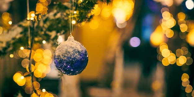 Christbaumschmuck bedeckt Schnee im Freien Weihnachtsbaum mit dekorativen blauen Glühbirnen