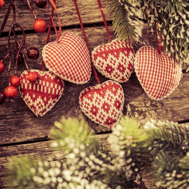 Christbaumschmuck hängt am Ast vor Holzuntergrund Winterurlaub