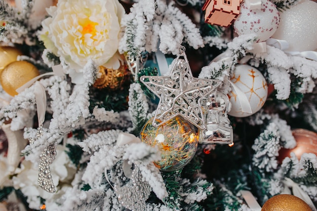 Christbaumschmuck. verschiedene weihnachtsverzierungen, engel, bälle, schneeflocken auf dem baum. weihnachtsdekorationen .