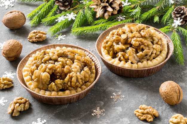 Christbaumzweige und leckere Kuchen mit Zitronenmarmelade und karamellisierten Walnüssen für die Weihnachtsfeier