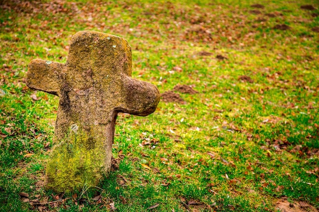 Christentum Religion Symbol Steinkreuz auf Friedhof und Gras