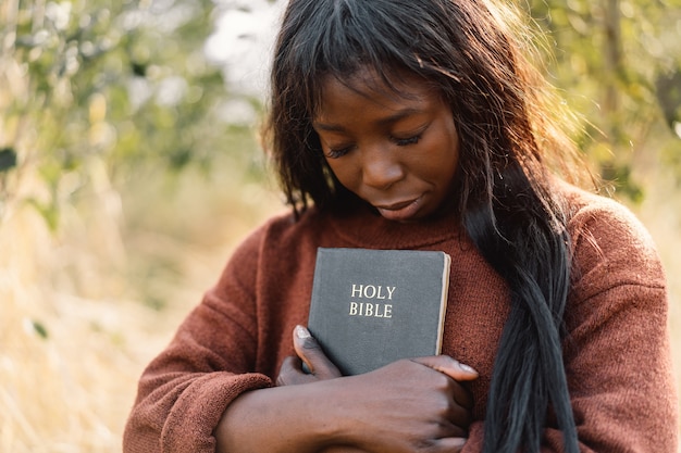 Christian afro girl tiene la Biblia en sus manos