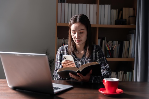 Christian concepto de tecnología en línea manos orando de cristiano con computadora digital portátil iglesia en línea en vivo para el servicio dominical hombre católico asiático están leyendo la Biblia libro y estudio en línea