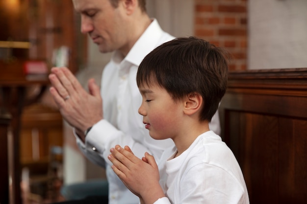 Foto christian hombre y niño orando vista lateral