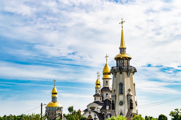 Christliches Kirchenkreuz im hohen Kirchturm für Gebetsfotografie, bestehend aus einer schönen Kirche mit Kreuz auf dem Kirchturm bis zum aufrichtigen Gebetskreuz. Der Kirchturm ist ein Kirchengebet über klarem Himmel