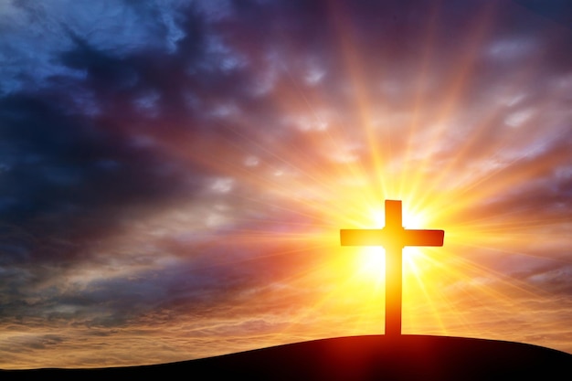 Christliches Konzept: Das Kreuz auf Bergsonnenunterganghintergrund