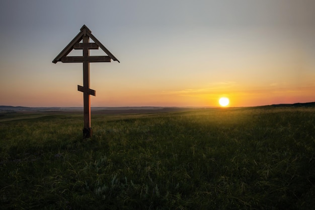 Foto christliches kreuz bei sonnenuntergang mit platz für text religionskonzept