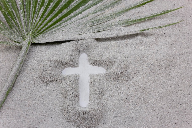 Christliches Kreuz in Asche mit Palmblatt