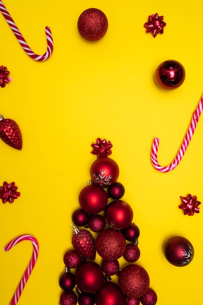 Christmass flatlay Weihnachtsbaum gesäumt mit Christbaumschmuck und Christbaumspielzeug