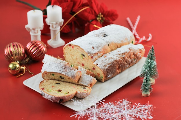 Christstollen auf rustikalem Hintergrund. Traditionelles Weihnachts-Festgebäck-Dessert aus dem Deutschen. Stollen zu Weihnachten, Red Concept