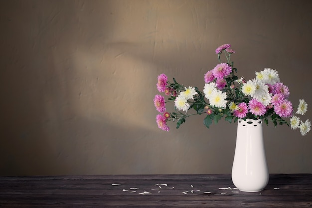 Chrysanthemen in Vase auf altem Holztisch