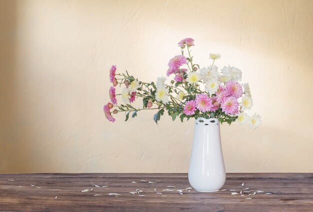 Chrysanthemen in Vase auf altem Holztisch