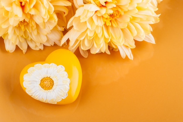 Chrysanthemenblumen auf einer Platte und einem Herzen