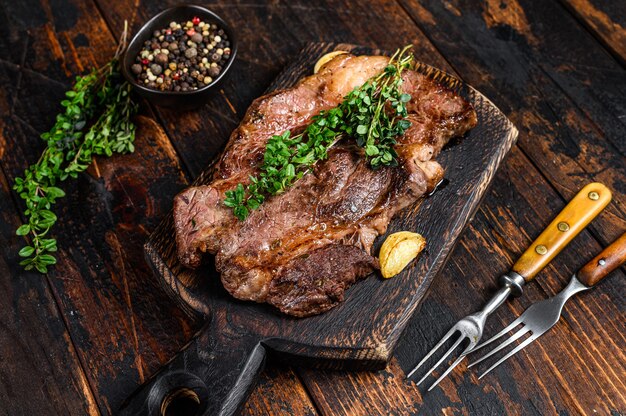 Chuck eye roll filete de carne de vacuno a la parrilla sobre una tabla para cortar