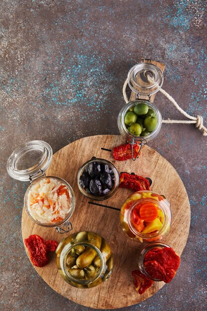 Chucrut, zanahorias en escabeche, pepinos en escabeche, aceitunas y aceitunas en escabeche, tomates secos en frascos de vidrio