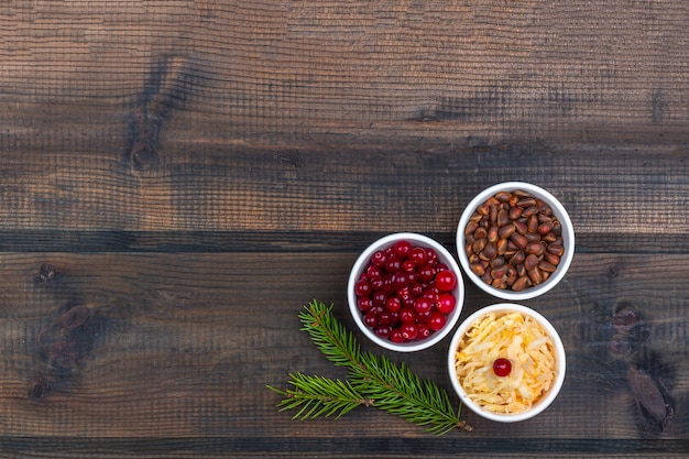 Chucrute ou couve fermentada com cranberries e pinhões em fundo de madeira rústico. o conceito de alimentação saudável. comida orgânica e vegetariana, ingredientes de fermentação. fechar-se