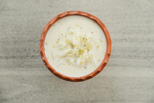 Chui pitha kheer firni servido em pote isolado na vista superior do tapete de bangali indiano e sobremesa paquistanesa mithai