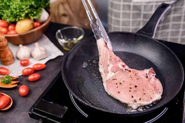 Chuleta de cerdo casera con ensalada. Aprendizaje en línea para cocinar una dieta y alimentos saludables cuando se queda en casa durante el coronavirus.