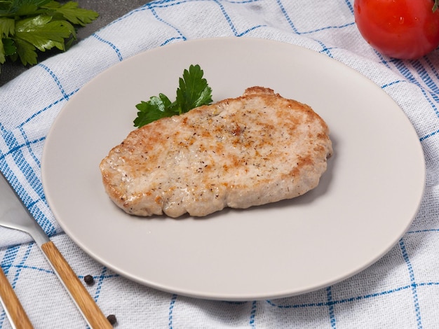 Chuleta de cerdo decorada con verduras en un plato gris