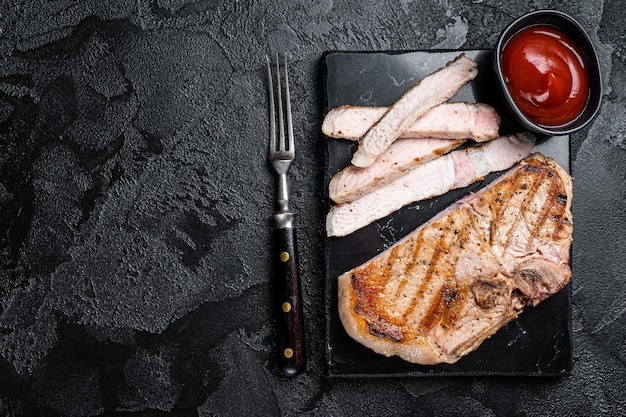 Chuleta de cerdo a la parrilla o filete de carne Tbone Fondo negro Vista superior Espacio de copia