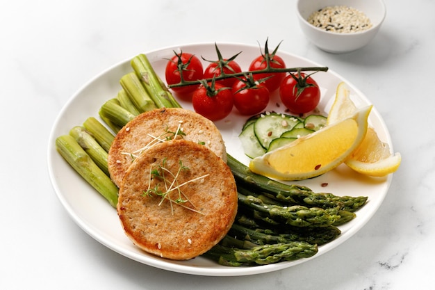 Chuleta frita con verduras, espárragos, pepinos y tomates cherry Idea de cena dietética Dieta cetogénica