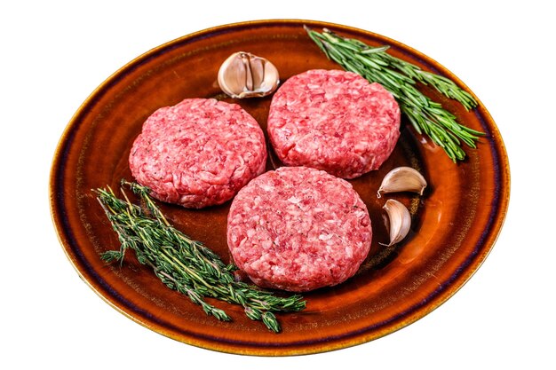 Chuletas de carne de hamburguesa cruda con carne picada y hierbas en un plato aislado sobre fondo blanco
