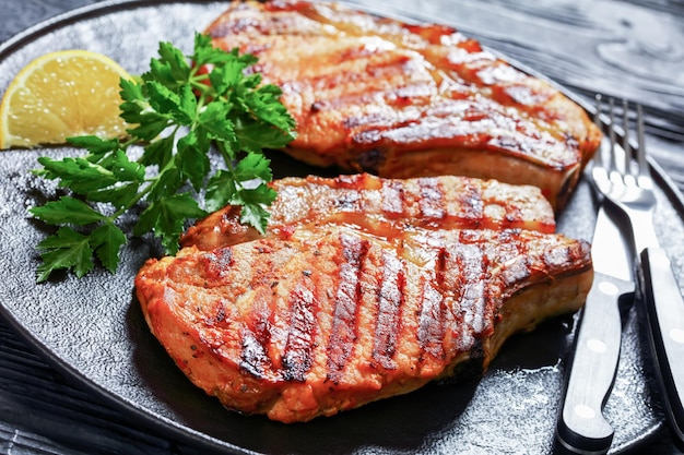 Chuletas de cerdo con hueso a la parrilla en un plato negro