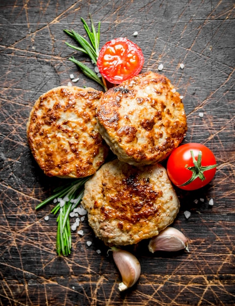 Chuletas con dientes de ajo, romero y tomates