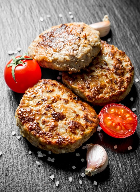 Chuletas con dientes de ajo y tomates