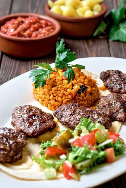 Chuletas turcas de carne de cordero y ternera y especias con ensalada y arroz