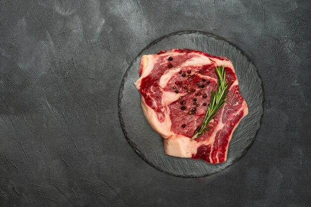 Chuletón de carne fresca en una pared negra