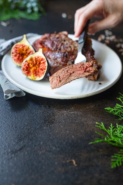 Chuletón de ternera a la parrilla sobre una placa blanca.