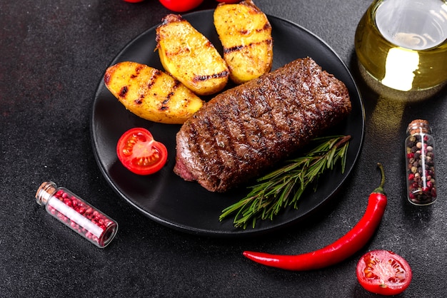 Chuletón de ternera con patatas, cebolla y tomates cherry. Jugoso bistec con mantequilla aromatizada