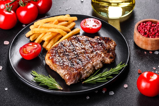 Chuletón de ternera con patatas, cebolla y tomates cherry. Jugoso bistec con mantequilla aromatizada