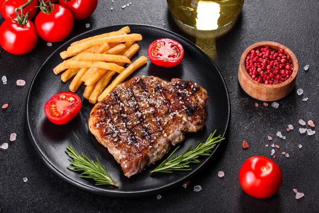 Chuletón de ternera con patatas, cebolla y tomates cherry. Jugoso bistec con mantequilla aromatizada